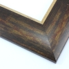 This bold, 2.5 " frame features a reverse profile design; it slopes from thickest at the inner edge to thin at the outer. Overlapping brown, gold and deep red layers result in a faux wood-grain, rustic effect. The cracked gold foil inner edge slants in toward the artwork.
Best suited to large artwork; the perfect border to a rural or autumnal reproduction.